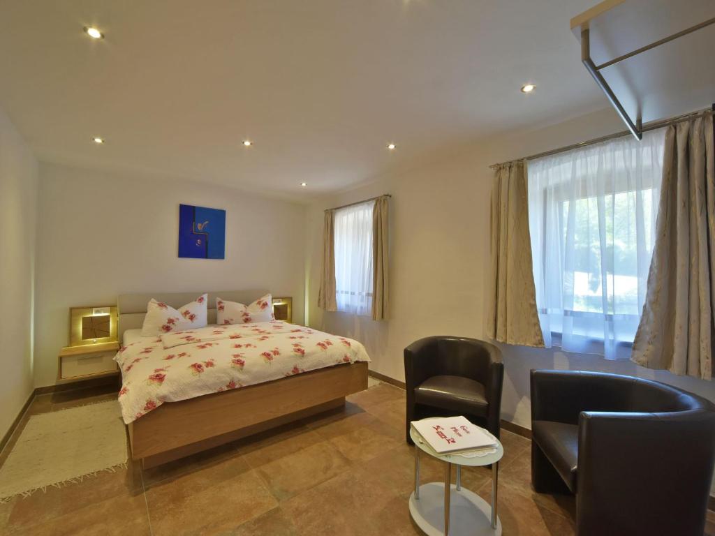 米尔施塔特兰德埃布拿旅馆的一间卧室配有一张床、一张桌子和一把椅子