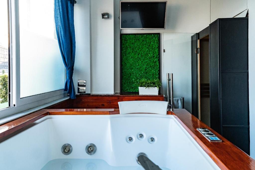 那不勒斯科沃德利安久依尼酒店的带窗户的浴室内的白色大浴缸