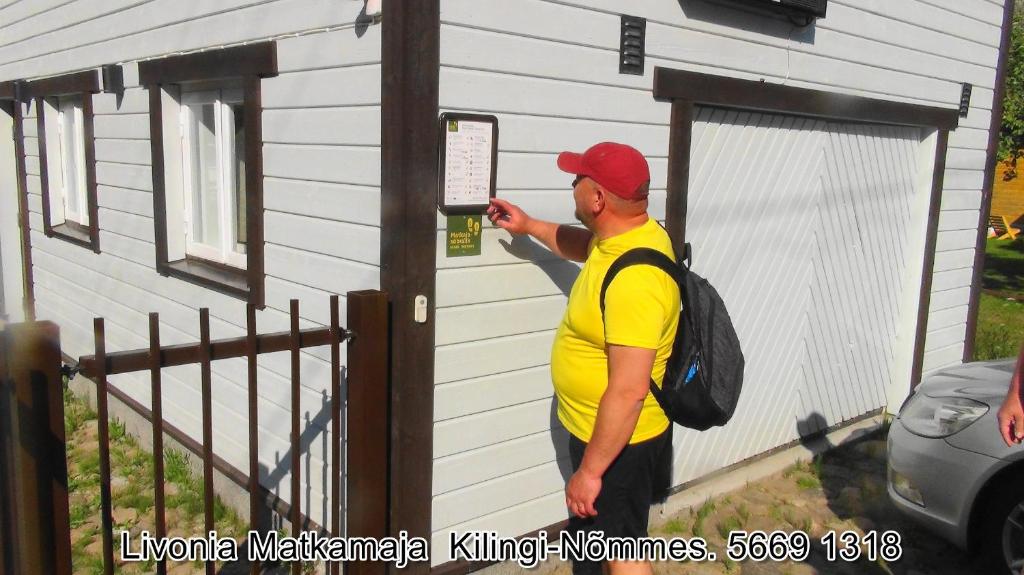 Kilingi-NõmmeLivonia Matkamaja的一个人在看房子上的标志