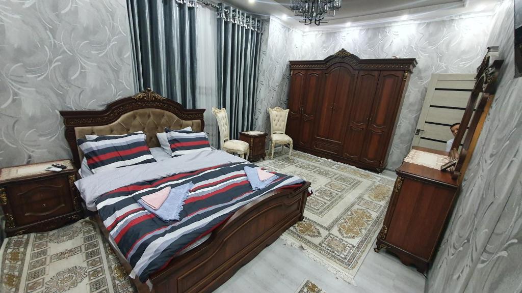 塔什干Fayzli GuestHouse的一间卧室配有一张带木制床头板的床