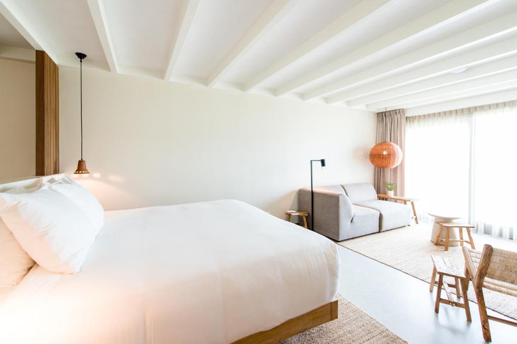 内斯Van Heeckeren Apartments & Suites Nes的白色卧室配有床和椅子