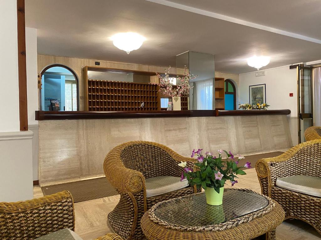 勒托阳尼Hotel San Pietro的一间房间,配有椅子和鲜花桌子