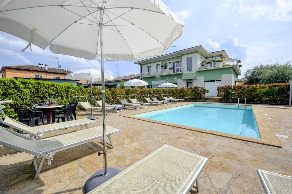 佩斯基耶拉德加达La Forgia Apartments的一个带椅子和遮阳伞的游泳池