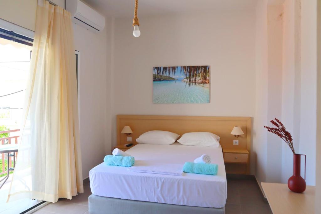 阿马林索斯Το Κοράλι的卧室配有白色的床和窗户。