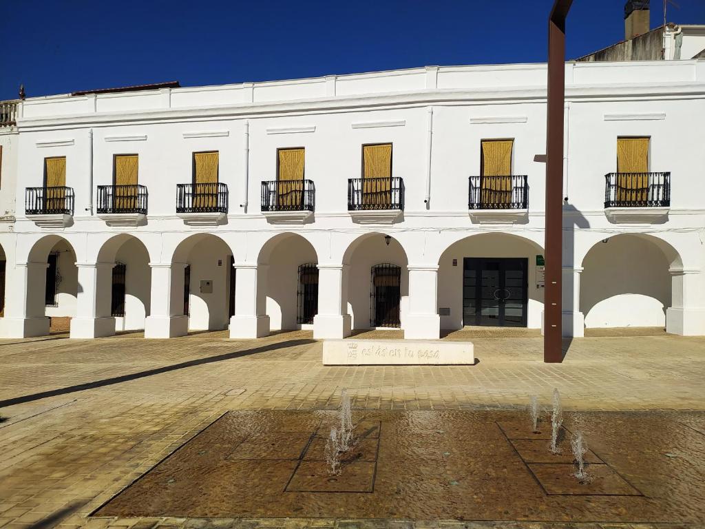 Herrera del DuqueCasa Rural "Laplaza23"的一座白色的大建筑,在庭院里有一个标志