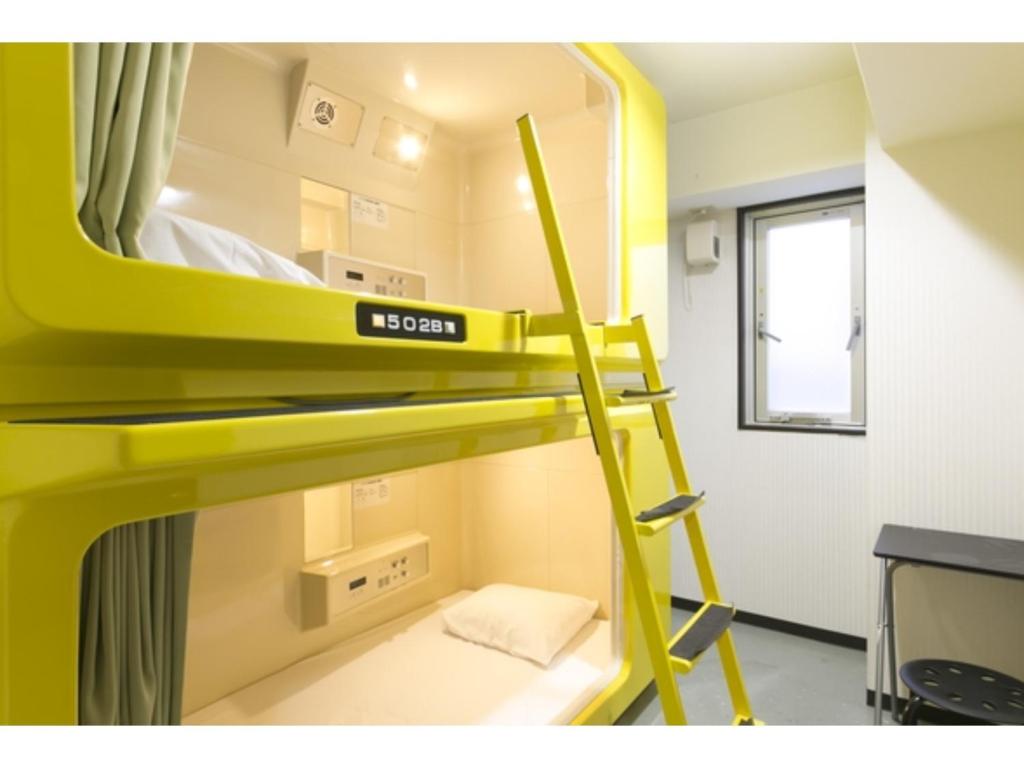 大阪Hotel Shin-Imamiya - Vacation STAY 36286v的一张黄色的双层床,在房间里设有梯子