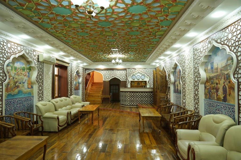 希瓦Shaherezada Boutique Hotel的一间设有椅子和天花板及绘画的房间