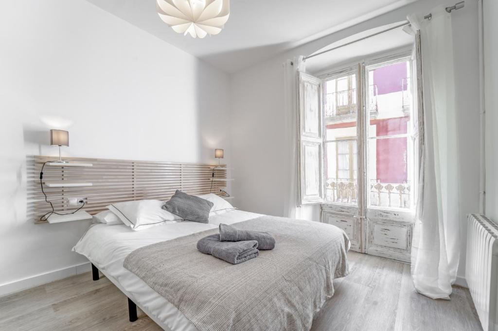 普奇塞达3.2 Apartamento Coma Oriola的白色卧室配有带两个枕头的床