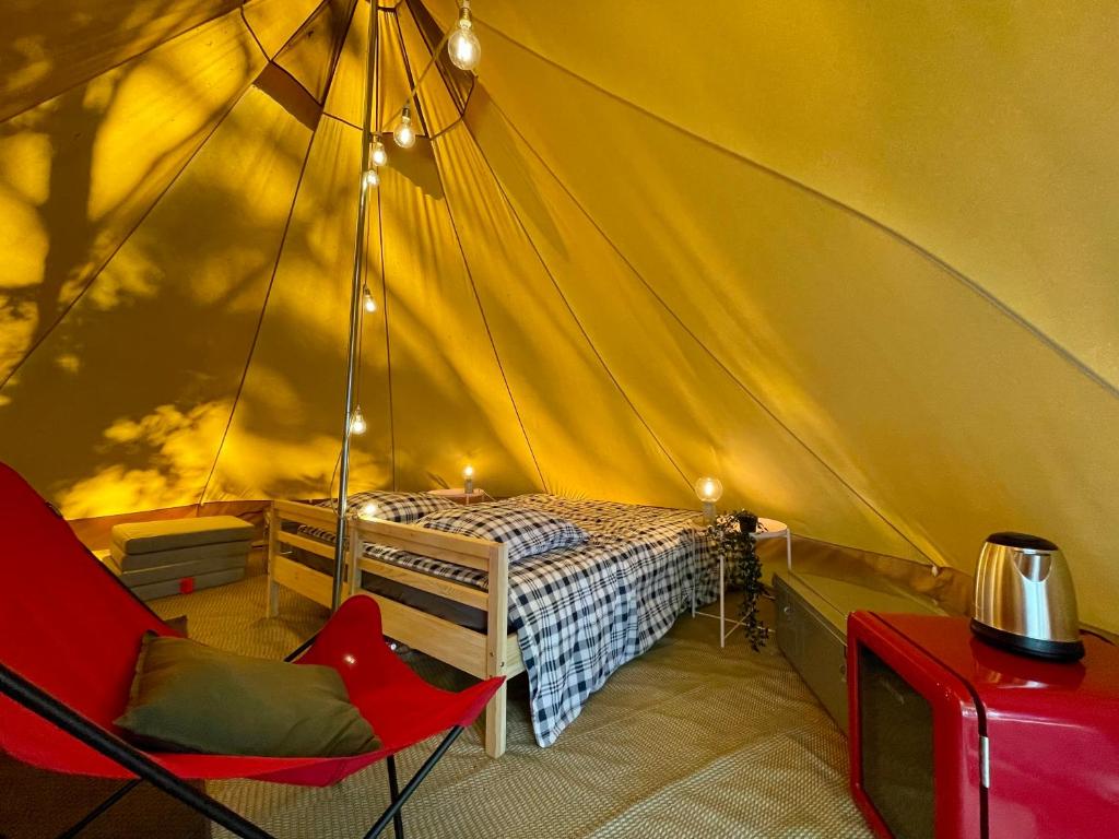 波讷地区圣朱利安Tente Indiana Chênes - La Téouleyre的一间卧室配有一张床铺,帐篷内提供一把椅子