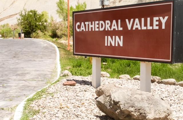 CainevilleCathedral Valley Inn的道路上人造山谷宾馆的标志