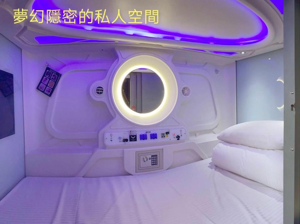 台北黑熊好眠站旅馆 (台北桥店)的配有床和圆镜子的客房