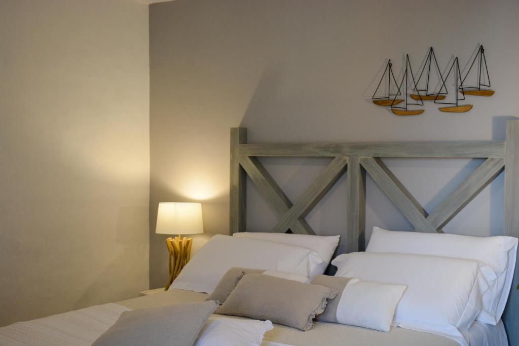 滨海波利尼亚诺Dimora Lilla的卧室配有两张白色床,墙上挂着帆板