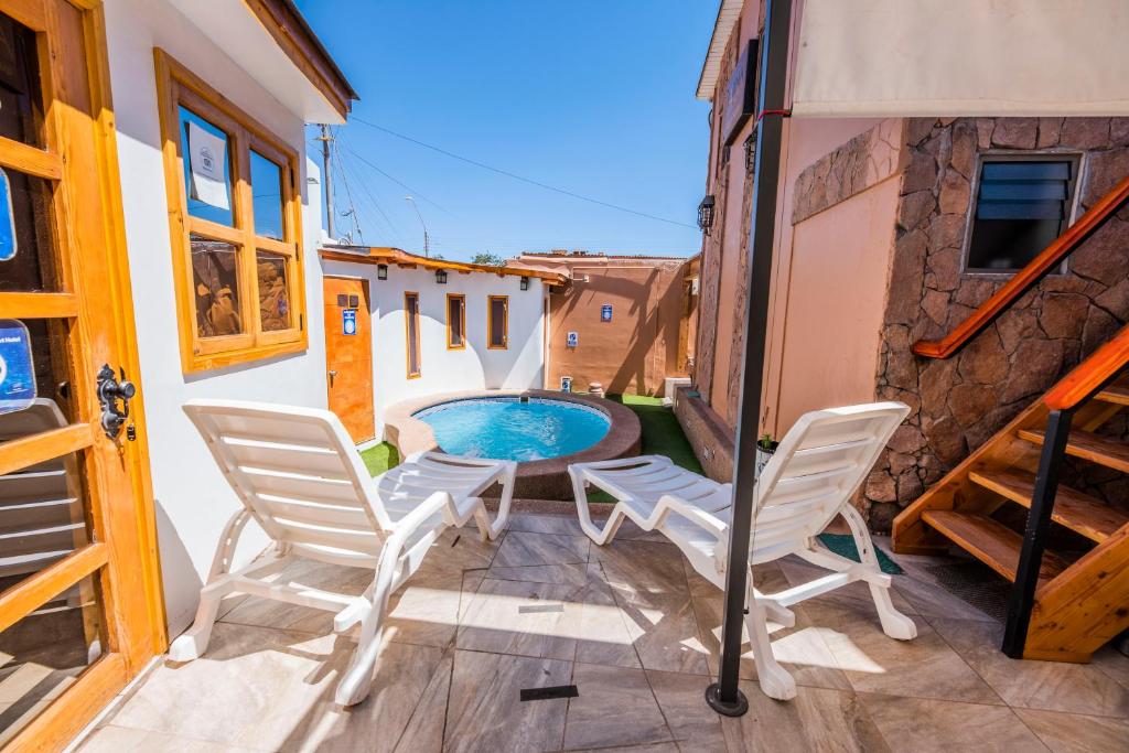 圣佩德罗·德·阿塔卡马Hotel Parina Atacama的一个带两把椅子的庭院和一个游泳池