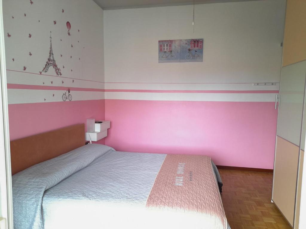 塞里亚泰BIKE HOUSE 1 "silver"的一间卧室配有一张粉红色墙壁的床