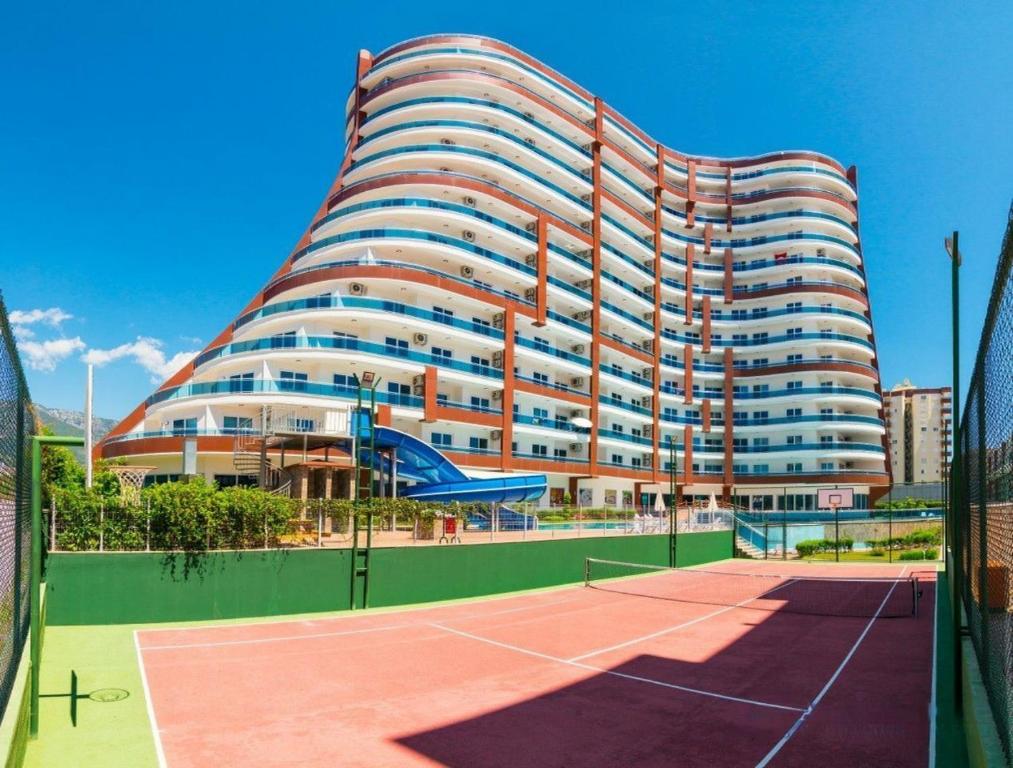 阿拉尼亚Lumos SPA ALL-IN apartment in Luxury resort full facilities的一座大型建筑,前面设有网球场