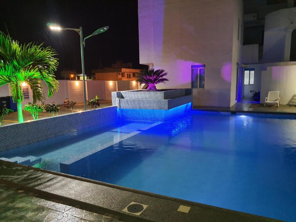 通苏帕Departamento amoblado en Tonsupa的夜晚的游泳池,灯光蓝色