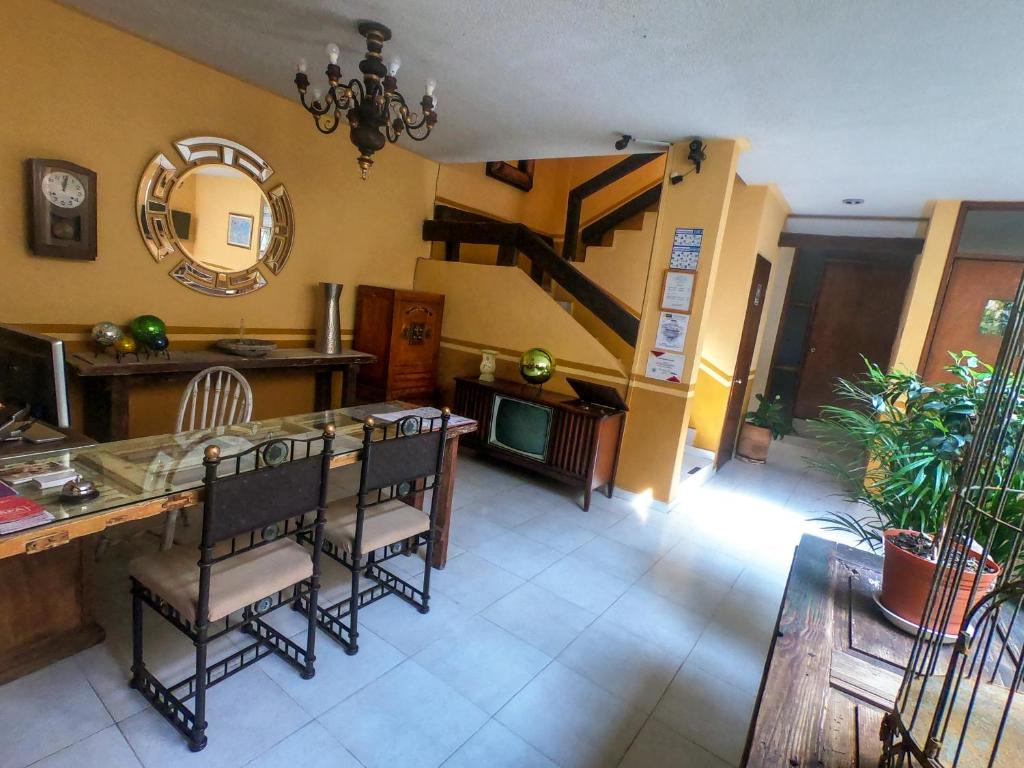 萨卡特卡斯Posada del Carmen的一间带桌椅和楼梯的客厅