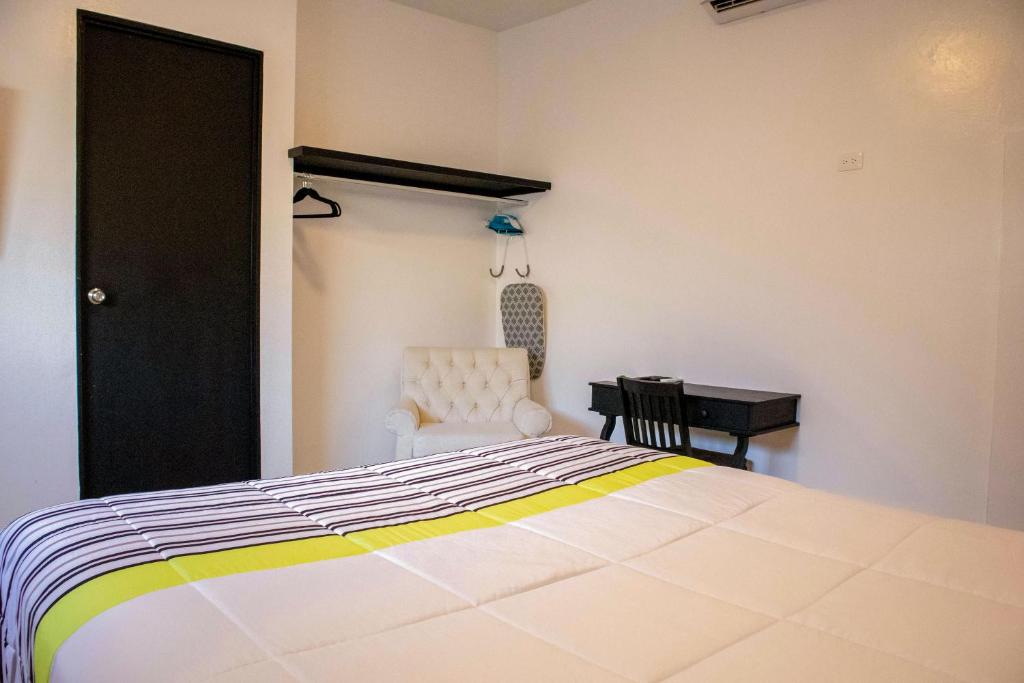 卡波圣卢卡斯Donjuan By Melida Hotel的一间卧室配有一张床、一把椅子和一张书桌
