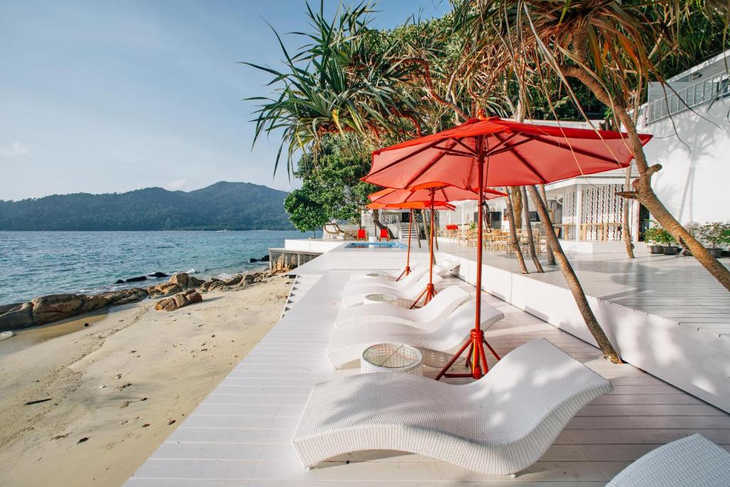 丽贝岛Casa De Lipe的海滩上一排白色椅子和一把遮阳伞