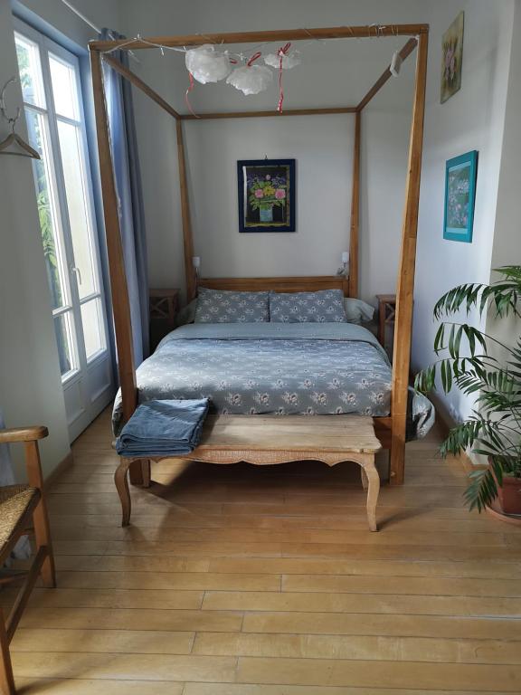 特鲁瓦Chambre en ville dans un esprit campagne的一间卧室配有一张木架床