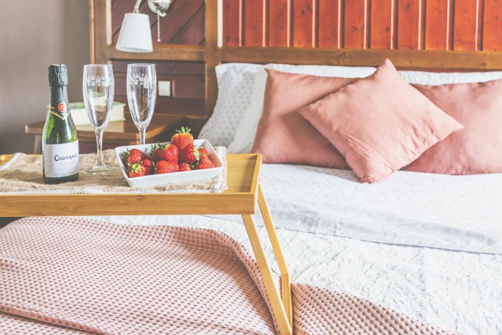 阿索马达Casa Layka, con maravillosas vistas al mar的一张带草莓和酒杯托盘的床