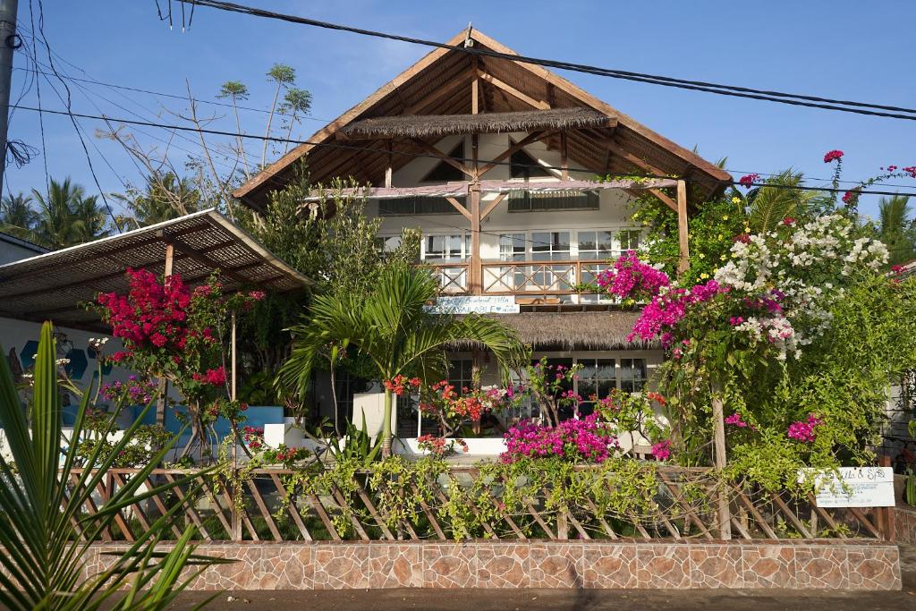 吉利阿尔Serenity Luxurious Beachfront Villa & Spa with private Infinity Pool, 8 Guests的前面有鲜花的房子