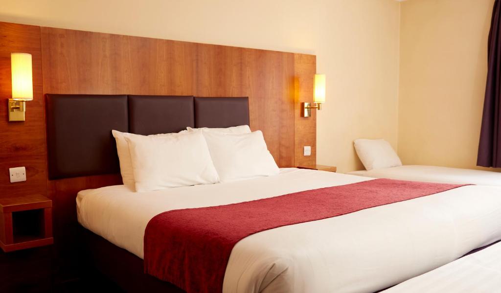 威登贝克Crossroads by Chef & Brewer Collection的酒店客房带两张床和红色毯子