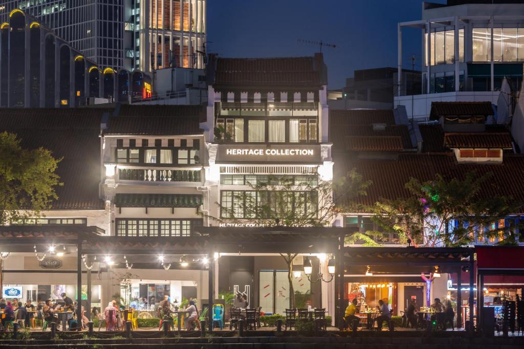 新加坡Heritage Collection on Boat Quay - Quayside Wing - A Digital Hotel的一群人晚上坐在建筑物外面