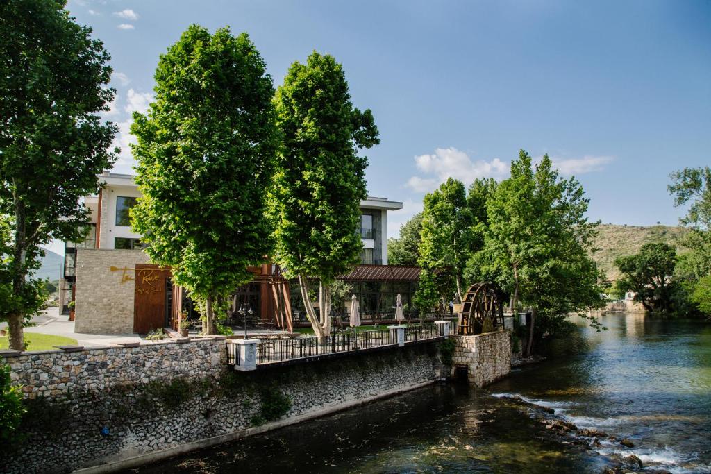 BunaHotel Buna Mostar的一座树木繁茂的河边建筑