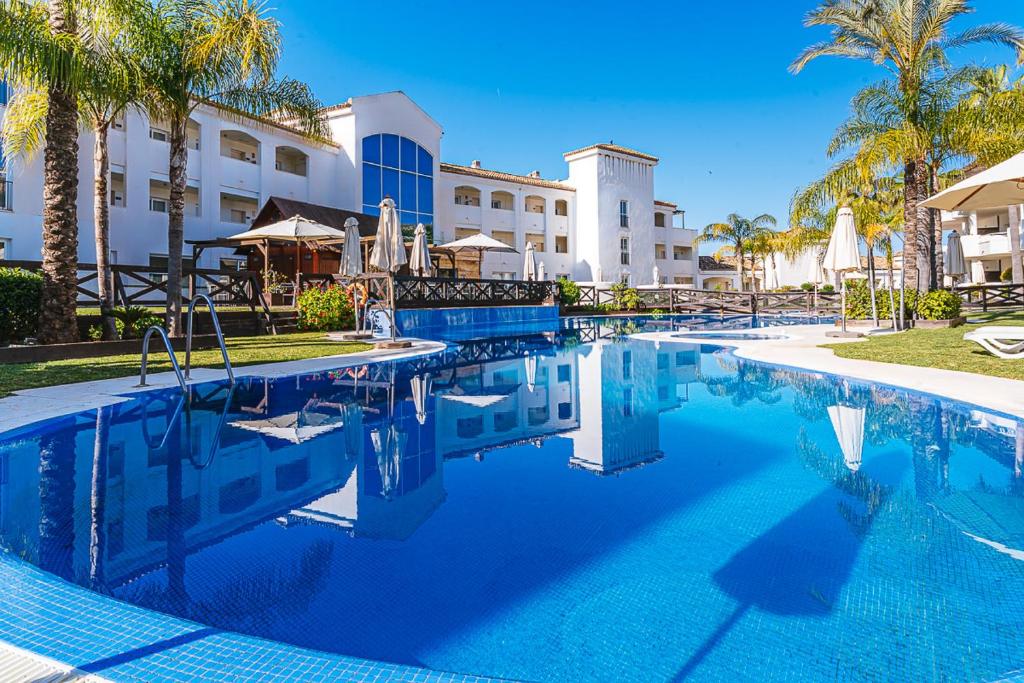 米哈斯Aparthotel Cordial Mijas Golf的棕榈树度假村的游泳池