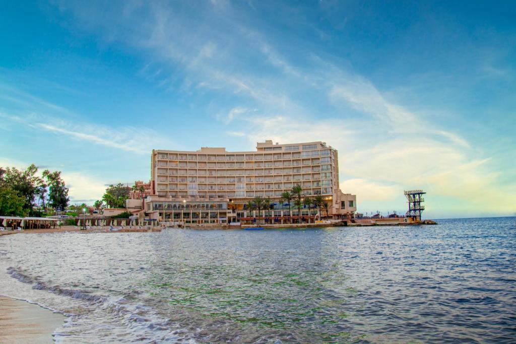 亚历山大Helnan Royal Hotel - Montazah Gardens的水岸上的一家大酒店