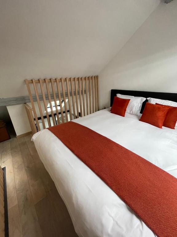 那慕尔L’Enjambée的卧室配有带红色枕头的大型白色床