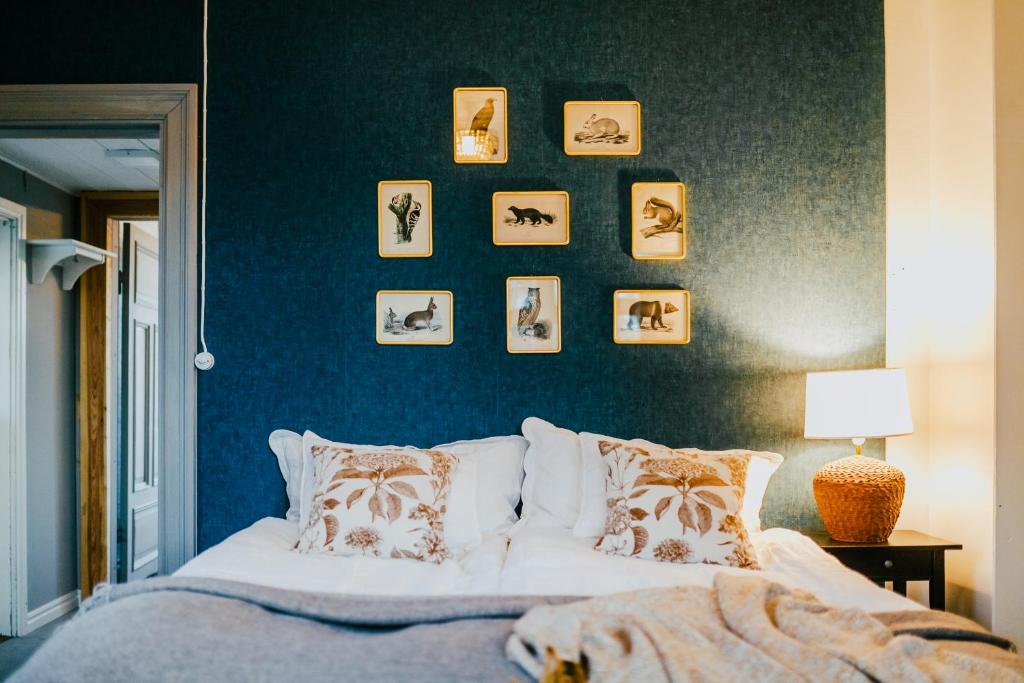 KauhajokiSalaisen Puutarhan Majatalo的一间卧室配有床和一张带照片的蓝色墙壁