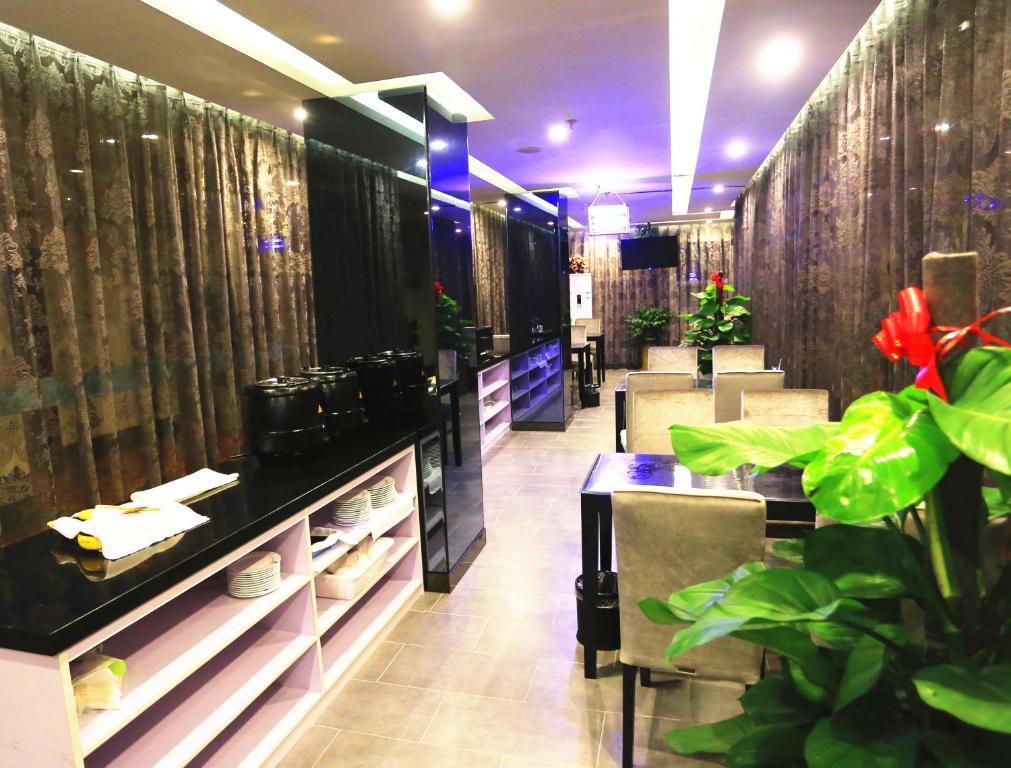 六安格林豪泰安徽省六安市磨子潭路义乌小商品市场商务酒店的一间餐厅,房间里摆放着桌子和植物
