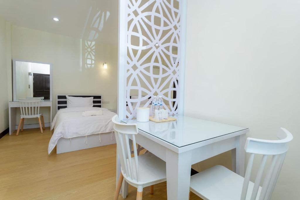 Ban Don KlangThai Guest House的白色的客房配有书桌和床。