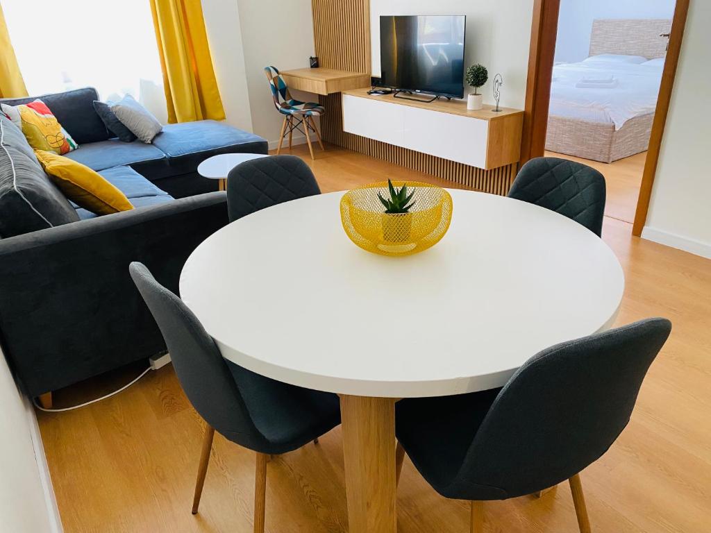 瓦尔纳Уютен апартамент в сърцето на прекрасен град Варна的客厅配有白色的桌子和椅子