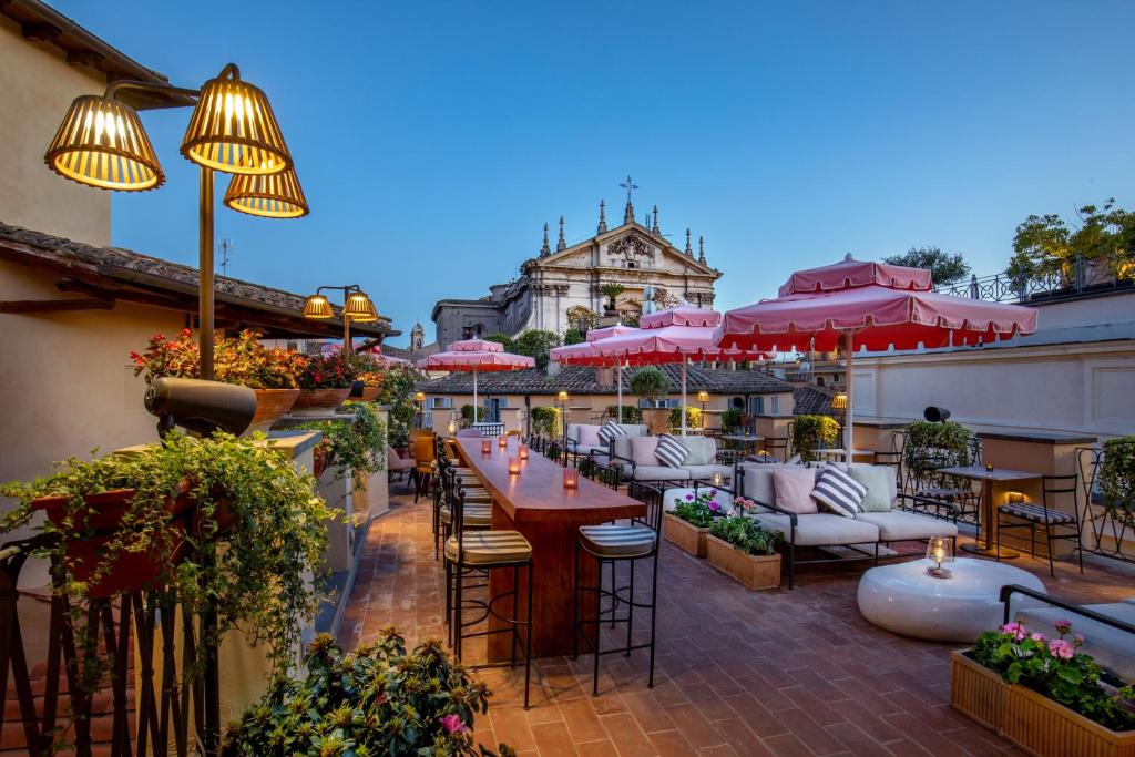 罗马切萨里9号酒店的一个带桌椅和遮阳伞的户外庭院。