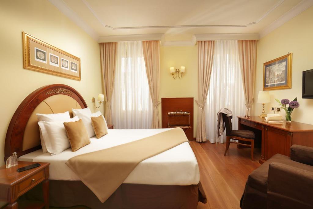 罗马霍姆斯酒店的配有一张床和一张书桌的酒店客房