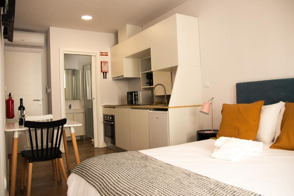 维拉·雷阿尔Apartamentos do Corgo的一间卧室配有一张床和一个小厨房