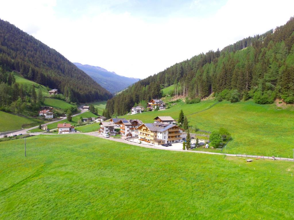 萨伦蒂诺Almhotel Bergerhof的绿色田野中房屋的空中景观