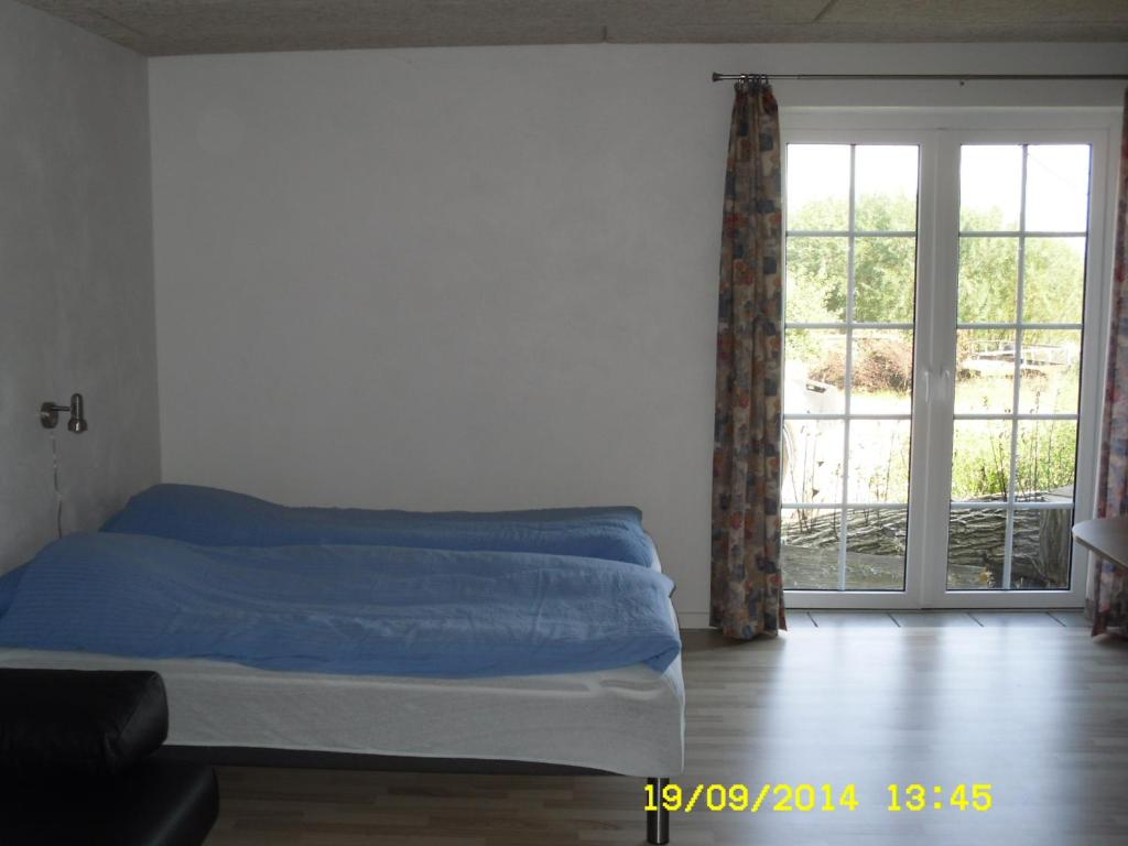 Guderup赫里斯凡公寓的一间卧室设有一张床和一个大窗户