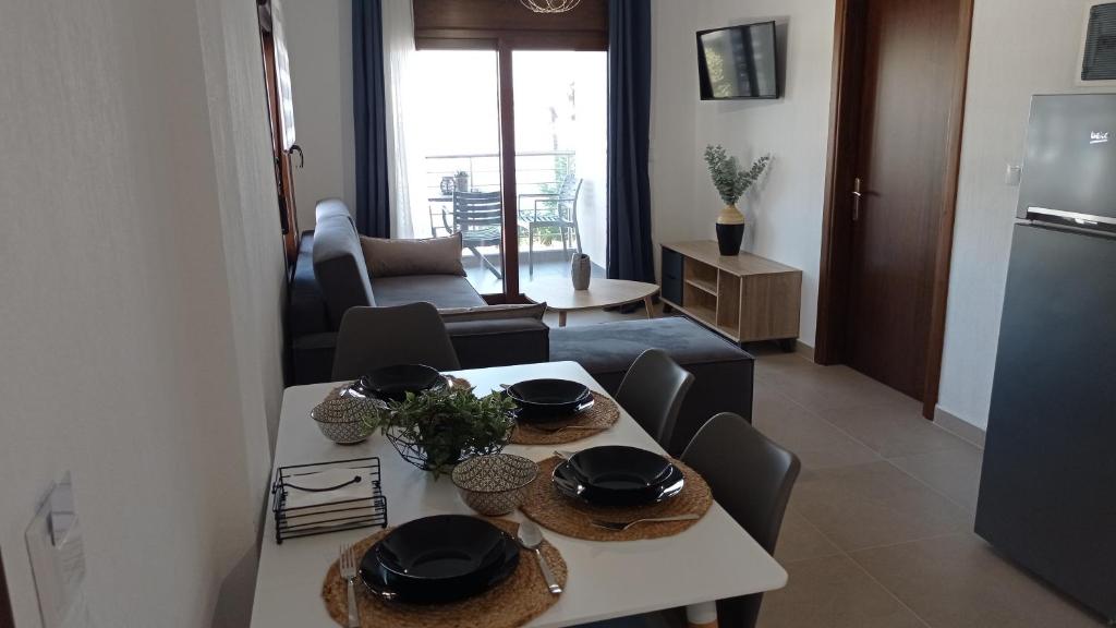 阿莫利亚尼岛Melograno Apartment的厨房以及带桌椅的起居室。