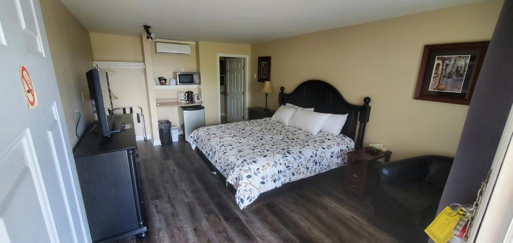 WhycocomaghFair Isle Motel的一间卧室配有一张床和一台电视