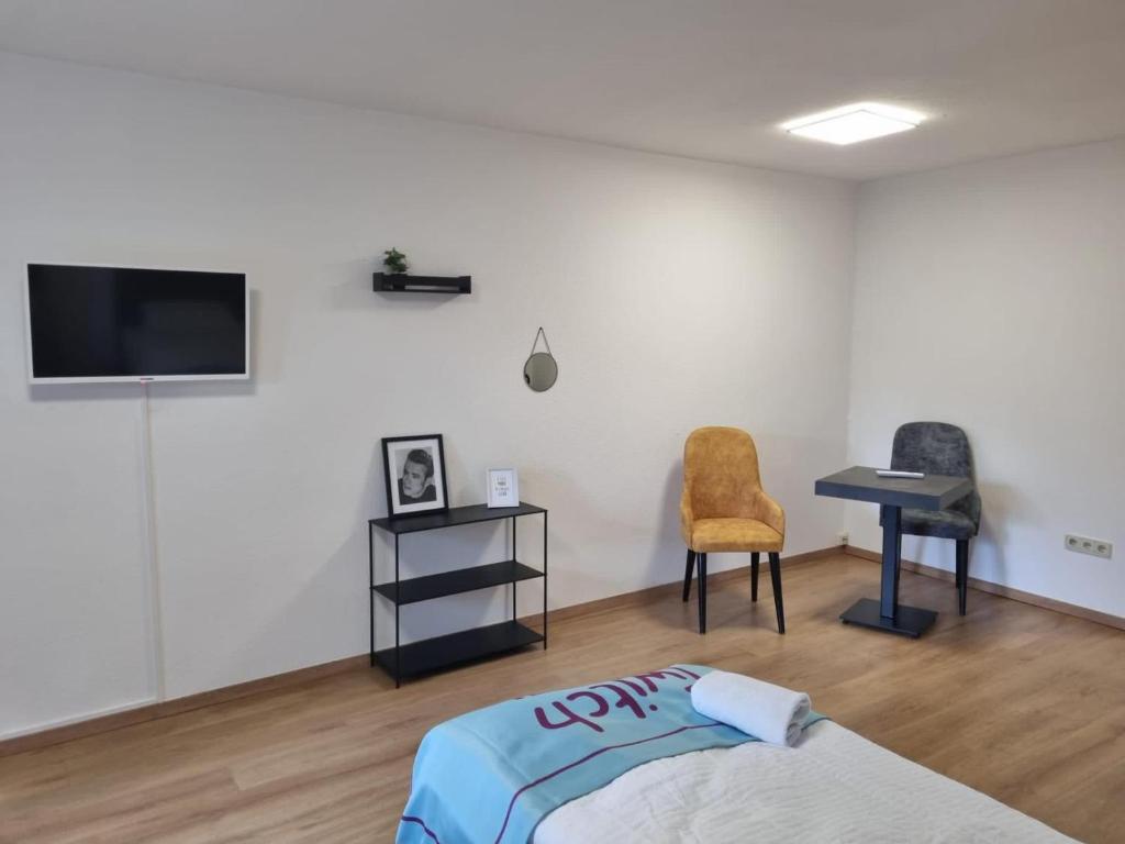 阿希姆Twitch Appartments的一间卧室配有一张床、一张书桌和一台电视。