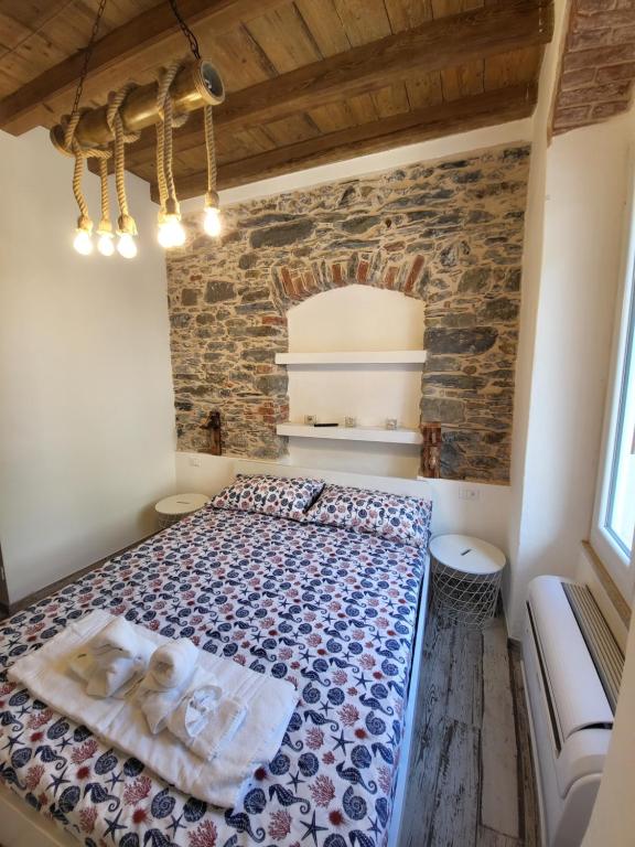 马纳罗拉L' Onda di Manarola的砖墙间内一间卧室,配有一张床