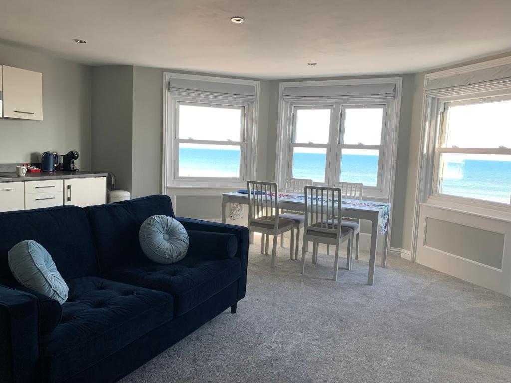沃辛Stunning Beachfront Apartment, Perfect Sea View.的客厅配有沙发和桌椅