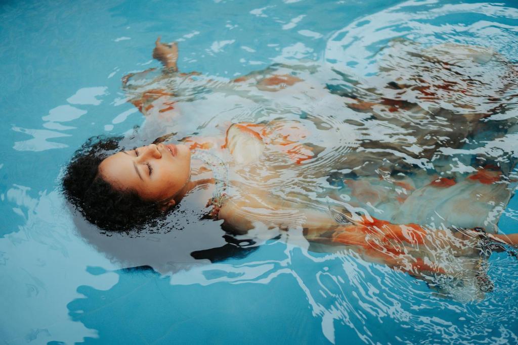 沙拉The Segond Hotel的躺在游泳池里的男孩