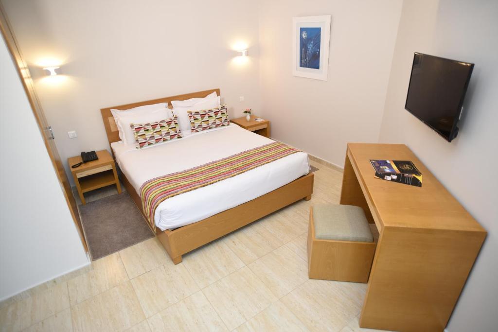 突尼斯Downtown Tunis Hotel的一间小卧室,配有一张床和一张桌子