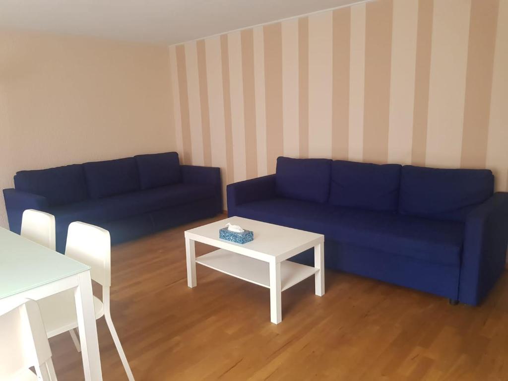 Haag2 Rooms cosy Apartment near Liechtenstein的客厅配有蓝色的沙发和桌子