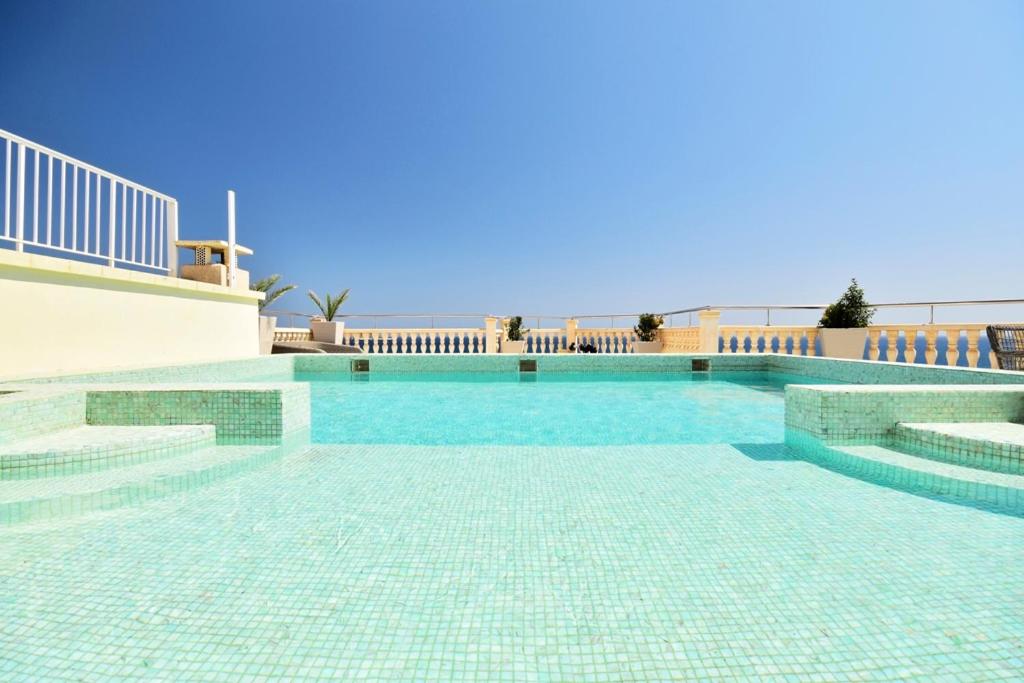 卡拉德费斯特拉特Atico Suite Ola Blanca的地面上一个蓝色瓷砖的游泳池